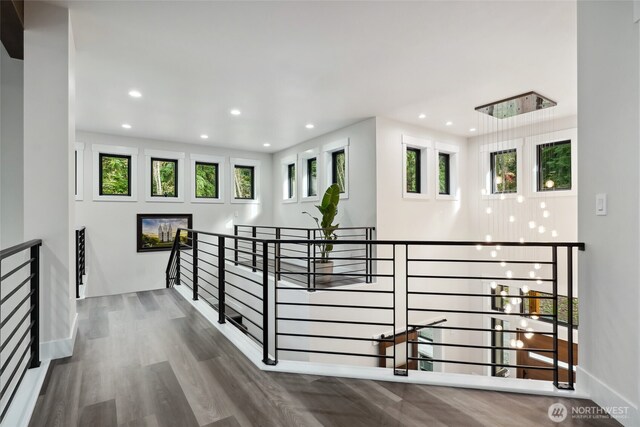 hall with recessed lighting, an upstairs landing, baseboards, and wood finished floors