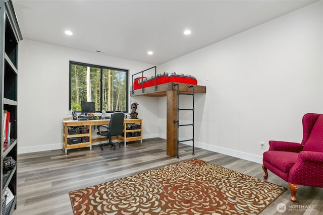 bedroom featuring baseboards, wood finished floors, and recessed lighting