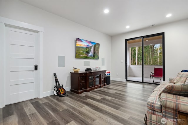 living area with baseboards, visible vents, wood finished floors, and recessed lighting