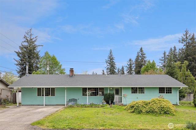ranch-style house with concrete driveway, fence, a chimney, and a front yard