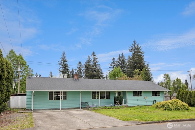 ranch-style home with a chimney, driveway, and a front lawn