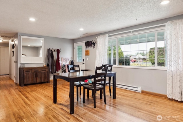 dining room featuring recessed lighting, a textured ceiling, baseboard heating, and light wood-style floors