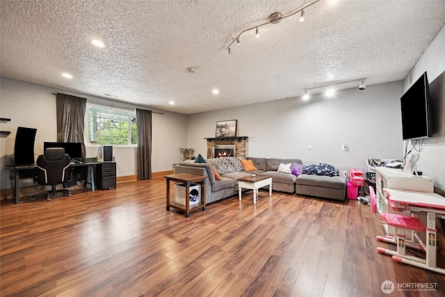 living room with a textured ceiling, rail lighting, and wood finished floors