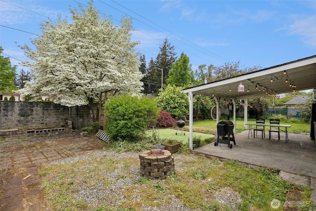 view of yard featuring a patio, a fenced backyard, and an outdoor fire pit