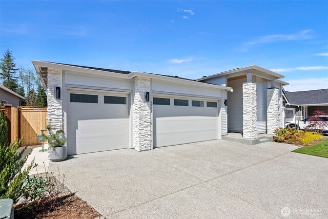 6346 Marymere Rd SW, Port Orchard, WA 98367 - prairie-style house with fence, an attached garage, concrete driveway, and stone siding