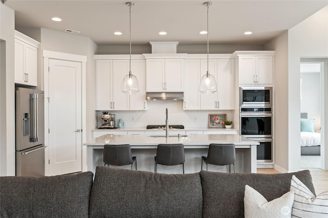 6346 Marymere Rd SW, Port Orchard, WA 98367 - kitchen with stainless steel appliances, under cabinet range hood, light countertops, white cabinets, and backsplash