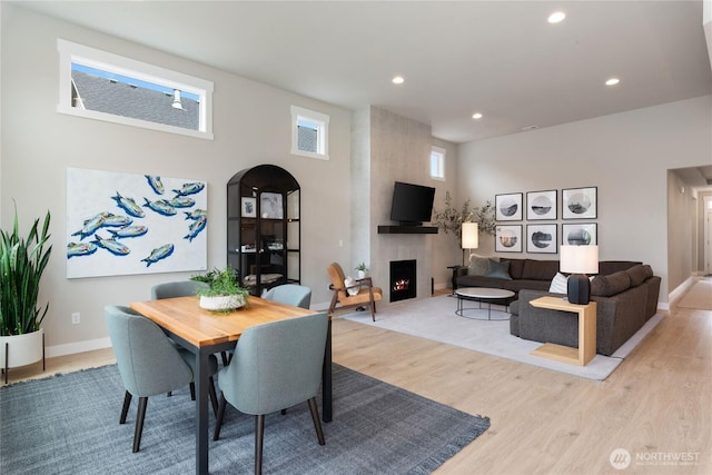 6346 Marymere Rd SW, Port Orchard, WA 98367 - dining space with arched walkways, light wood finished floors, a large fireplace, recessed lighting, and a high ceiling