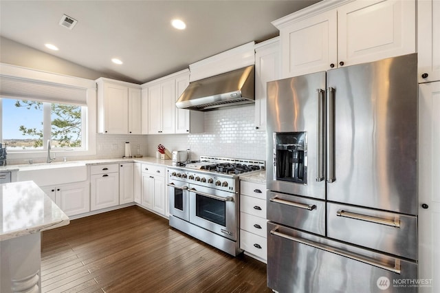 6 Pelican Pl SE, Moses Lake, WA 98837 - kitchen featuring lofted ceiling, wall chimney range hood, dark wood finished floors, a sink, and high end appliances