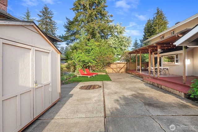 15126 NE 67th Pl, Redmond, WA 98052 - view of patio / terrace featuring an outdoor structure, a wooden deck, a fenced backyard, and a shed