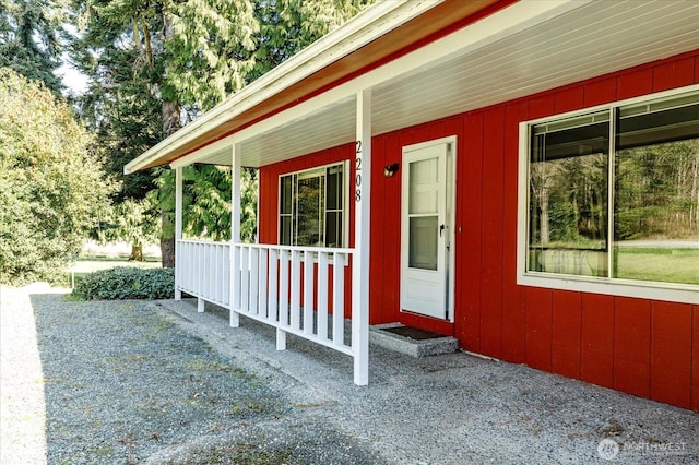 view of exterior entry featuring covered porch