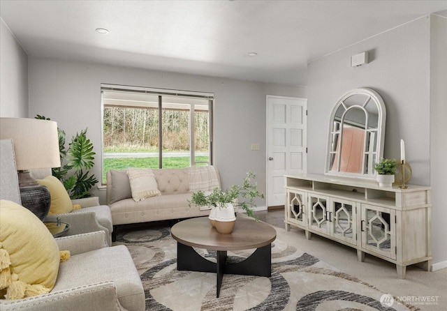 living area with baseboards and light carpet
