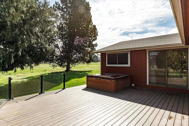wooden terrace with a lawn and a hot tub