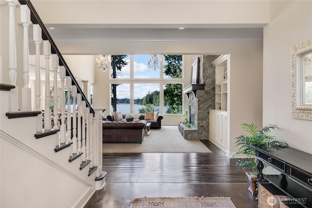 1220 Madrona Beach Rd NW, Olympia, WA 98502 - foyer with an inviting chandelier, ornamental molding, a stone fireplace, stairway, and wood finished floors