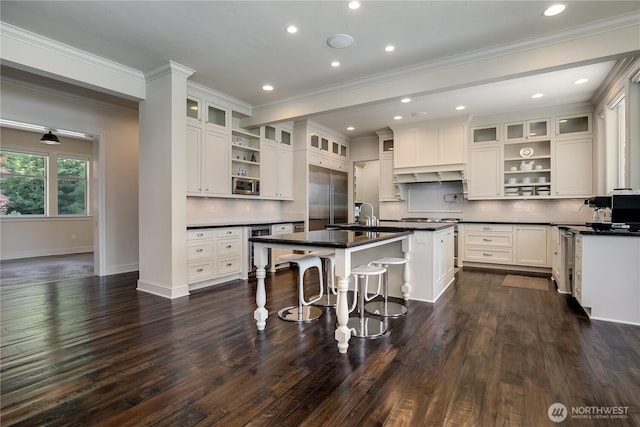 1220 Madrona Beach Rd NW, Olympia, WA 98502 - kitchen featuring built in appliances, a kitchen bar, open shelves, and dark countertops