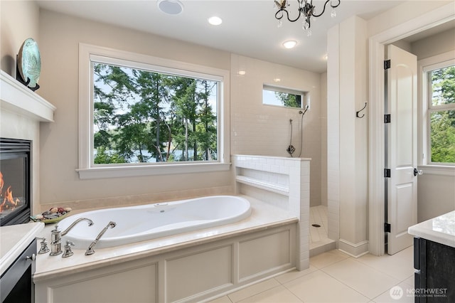 1220 Madrona Beach Rd NW, Olympia, WA 98502 - full bathroom featuring a tile shower, vanity, a glass covered fireplace, and a garden tub