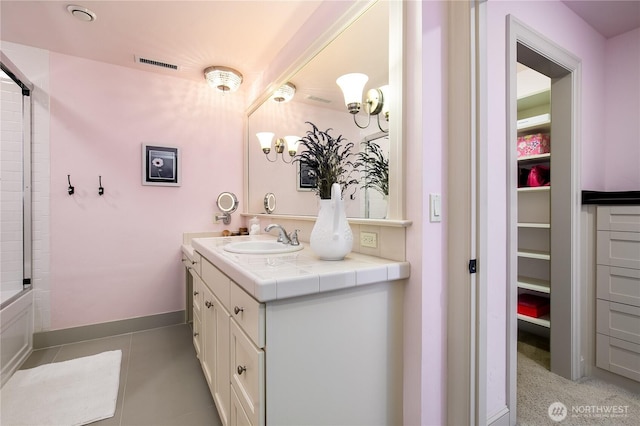 1220 Madrona Beach Rd NW, Olympia, WA 98502 - full bathroom with visible vents, baseboards, a spacious closet, vanity, and tile patterned floors