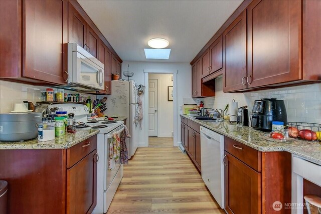 4509 Eastern Ave N Unit 1-3, Seattle, WA 98103 - kitchen with a skylight, white appliances, a sink, light wood-style floors, and backsplash