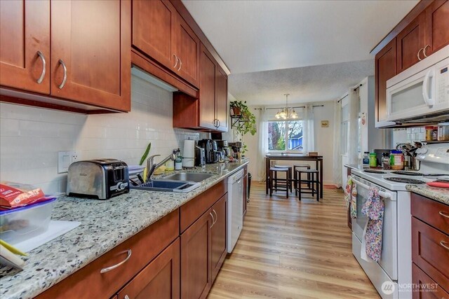 4509 Eastern Ave N Unit 1-3, Seattle, WA 98103 - kitchen with tasteful backsplash, white appliances, an inviting chandelier, a sink, and light wood finished floors
