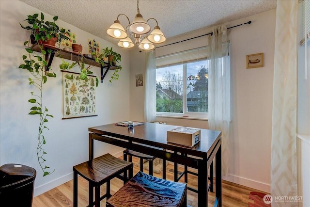 4509 Eastern Ave N Unit 1-3, Seattle, WA 98103 - dining space featuring a textured ceiling, light wood-style flooring, baseboards, and a chandelier