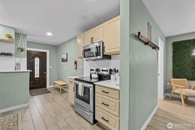 417 W 2nd St, Cle Elum, WA 98922 - kitchen with backsplash, light countertops, appliances with stainless steel finishes, and light wood finished floors