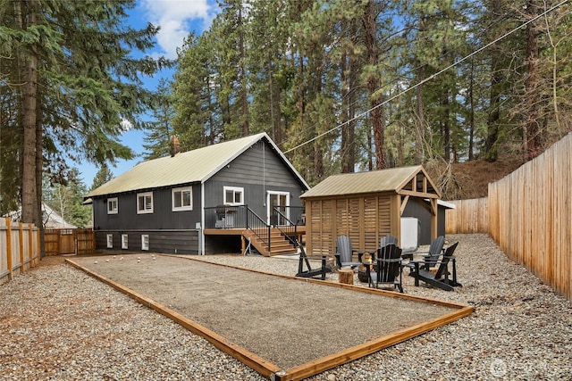 417 W 2nd St, Cle Elum, WA 98922 - rear view of property with a fenced backyard, an outdoor fire pit, an outbuilding, and a patio area