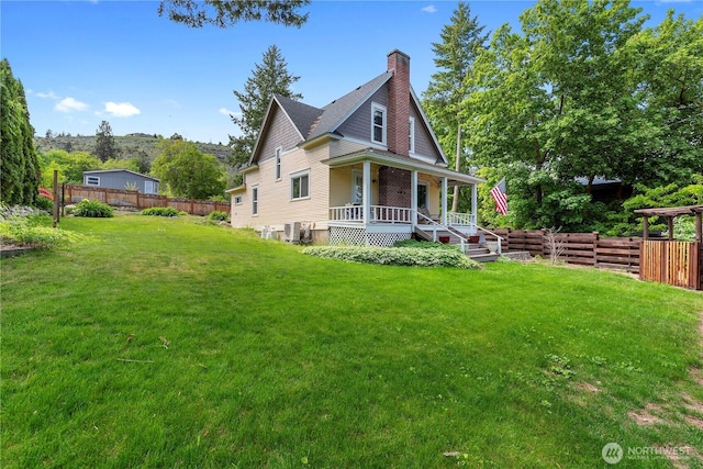 view of front of property with covered porch, a chimney, and central AC