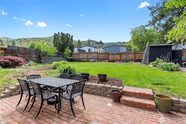 view of patio / terrace featuring a storage unit, an outdoor structure, and outdoor dining space