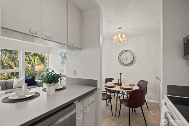 6201 Lake Washington Blvd NE Unit 206, Kirkland, WA 98033 - kitchen featuring light countertops, light colored carpet, a chandelier, range, and pendant lighting