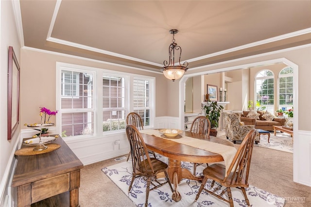dining space featuring light colored carpet, wainscoting, and crown molding