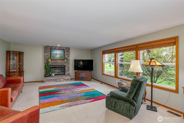 living room featuring carpet floors, baseboards, a fireplace, and visible vents