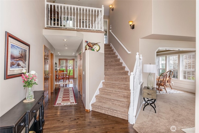 foyer with a high ceiling, wood finished floors, and stairway