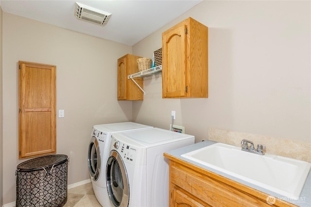 laundry area with visible vents, baseboards, cabinet space, a sink, and washing machine and dryer