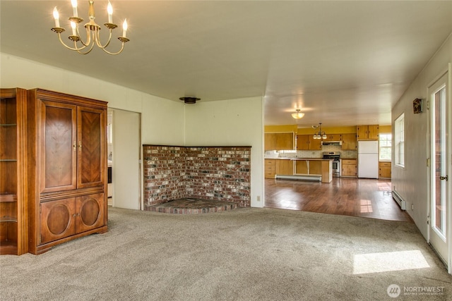 5296 Olson Rd, Ferndale, WA 98248 - unfurnished living room featuring dark carpet, a chandelier, and a baseboard heating unit