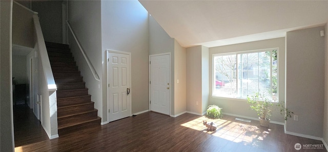 interior space featuring stairs, high vaulted ceiling, wood finished floors, baseboards, and visible vents