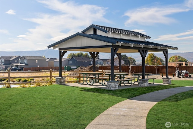 view of property's community with a residential view, a gazebo, fence, and a lawn
