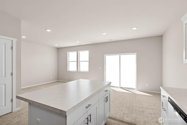 kitchen featuring light carpet, stainless steel dishwasher, and open floor plan