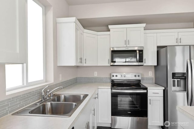 kitchen with light countertops, white cabinets, a sink, and stainless steel appliances