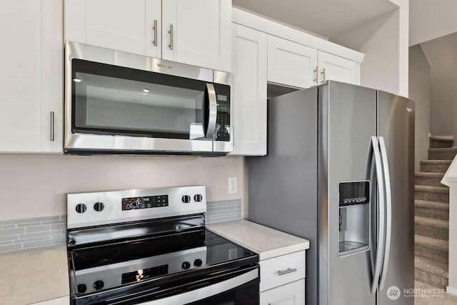 kitchen with white cabinets, light countertops, tasteful backsplash, and appliances with stainless steel finishes