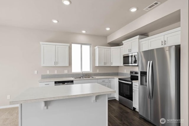 kitchen featuring recessed lighting, stainless steel appliances, a sink, visible vents, and white cabinets