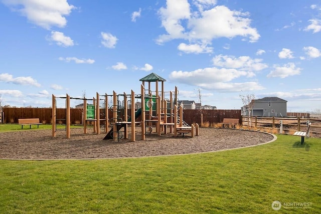 community play area with a lawn and fence