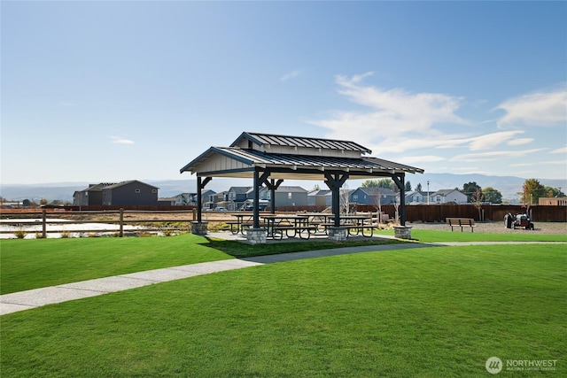 view of property's community featuring fence, a gazebo, and a yard