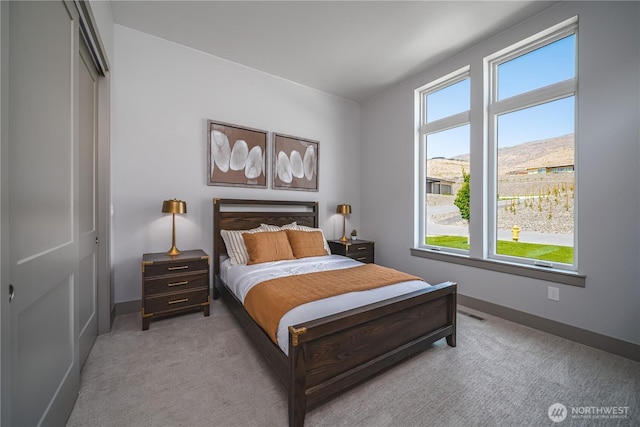 bedroom featuring light carpet and baseboards
