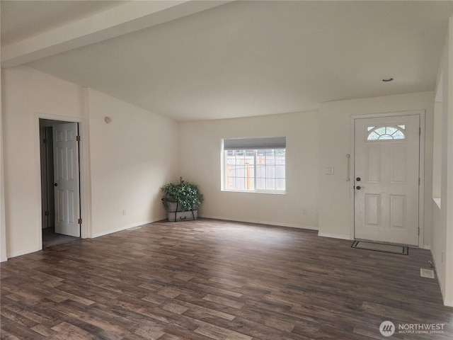 foyer entrance featuring baseboards, dark wood-type flooring, and vaulted ceiling