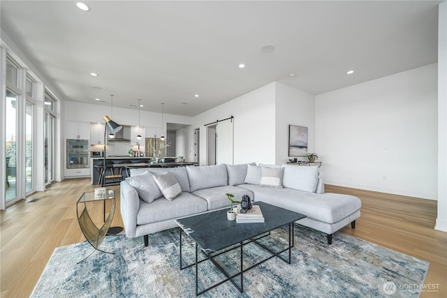 living area with baseboards, recessed lighting, and light wood finished floors