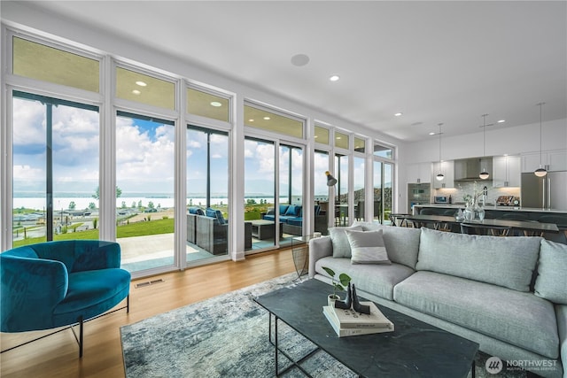 living room with visible vents, recessed lighting, and light wood-type flooring