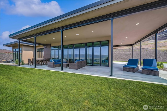 rear view of property featuring an outdoor living space, a patio area, and a lawn