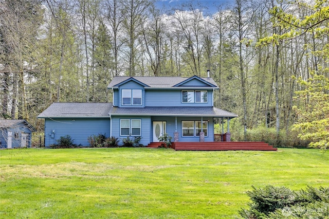 traditional-style house with roof with shingles, a front lawn, and a porch