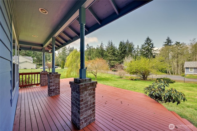 wooden deck with a yard and fence