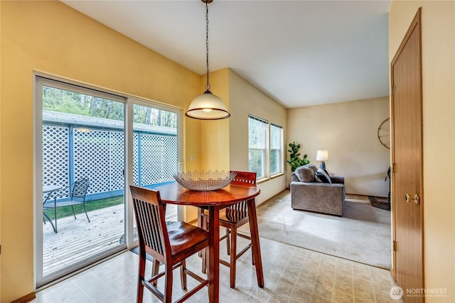 dining space with baseboards, light colored carpet, and light floors