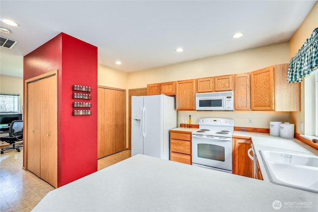 kitchen with white appliances, visible vents, recessed lighting, light countertops, and a sink
